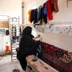 Iranian women weave handmade rugs in Nushabad