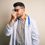 Médico tocándose la nariz