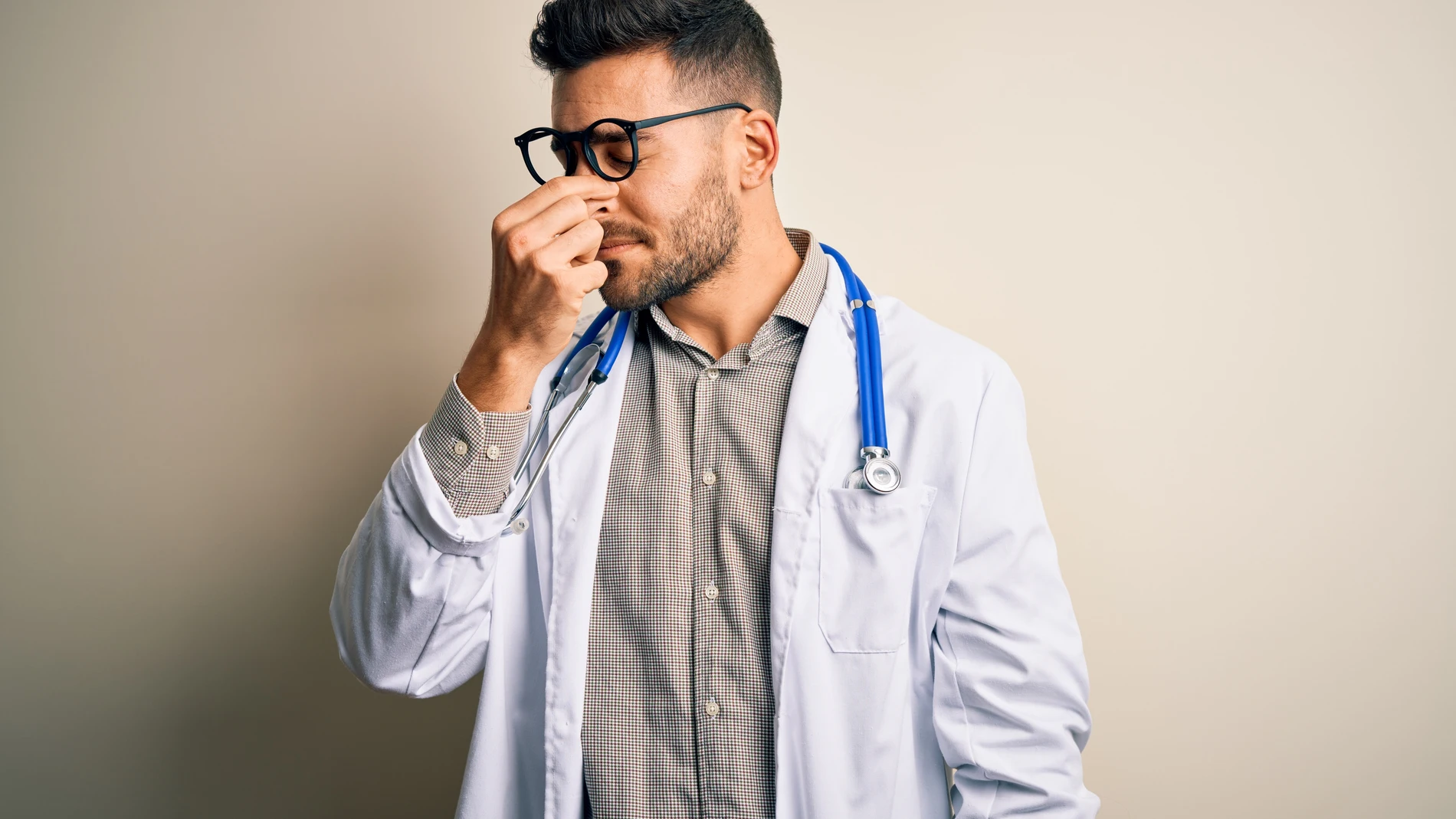 Médico tocándose la nariz