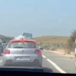 Joven corriendo a lo largo de la autopista en medio de un atasco
