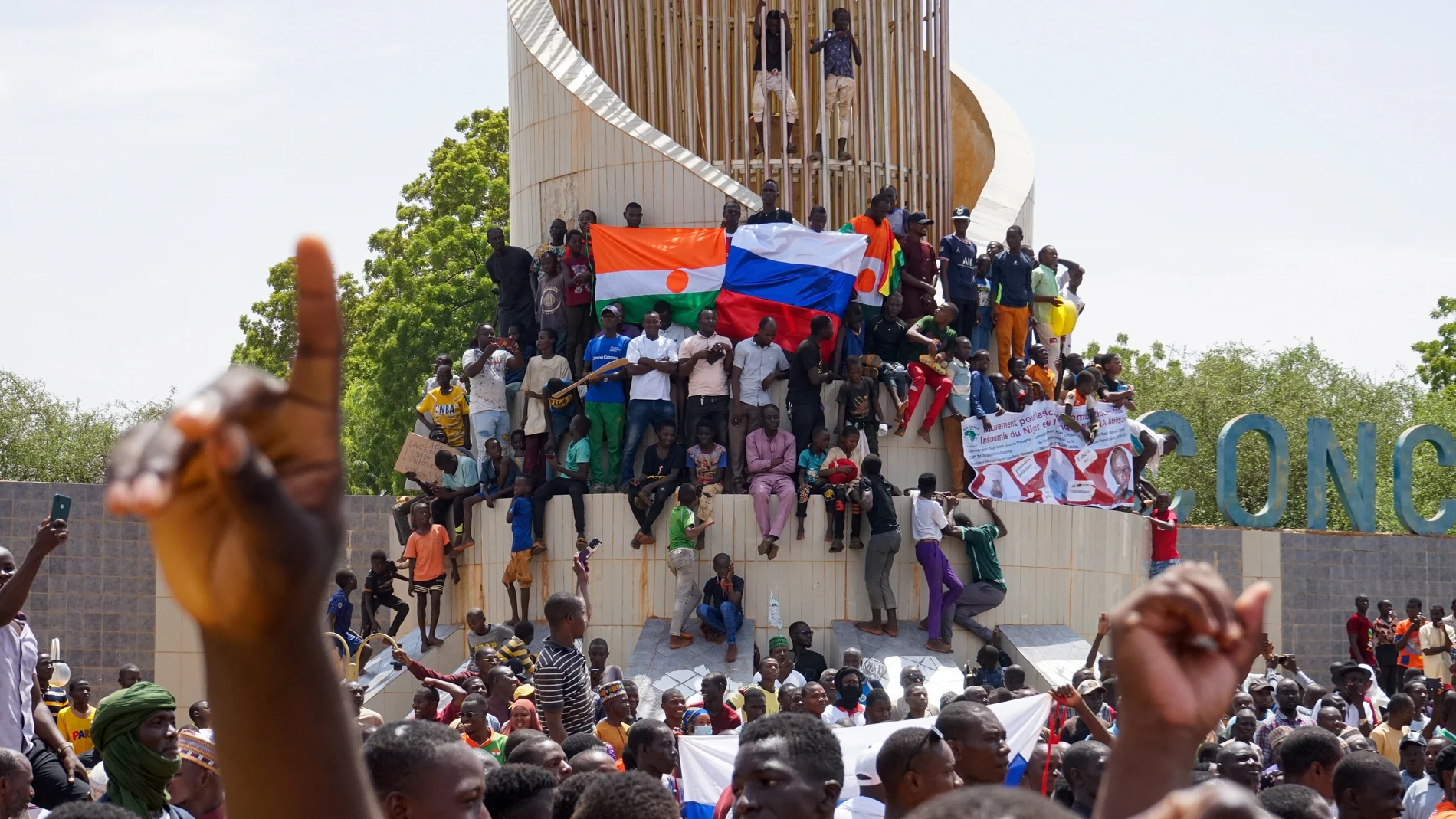 People display a Russia and a Niger flags outside the National Assembly building during a protest in Niamey, Niger, 30 July 2023.