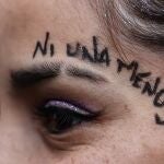 Una mujer participa con miles de mujeres en una marcha bajo la consigna "ni una menos".
