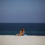 Una mujer toma el sol en la coruñesa playa de Riazor.