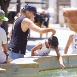 Un niño se refresca este martes en una fuente en Murcia. Las temperaturas se prevé que subirán aún más mañana miércoles en el día álgido de la ola de calor con termómetros que llegarán a 44 grados