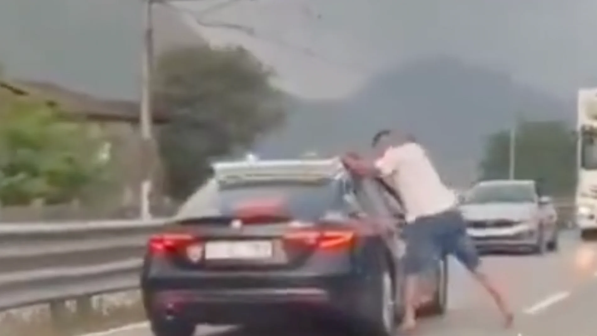 Un hombre a puñetazos, patadas e incluso arrancando las luces a un coche de policía en plena carretera