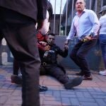 Un policía herido recibe auxilio de parte de los asistentes al mitin con el candidato presidencial Fernando Villavicencio y tras un tiroteo en el cual fue asesinado el aspirante hoy, en Quito (Ecuador). 