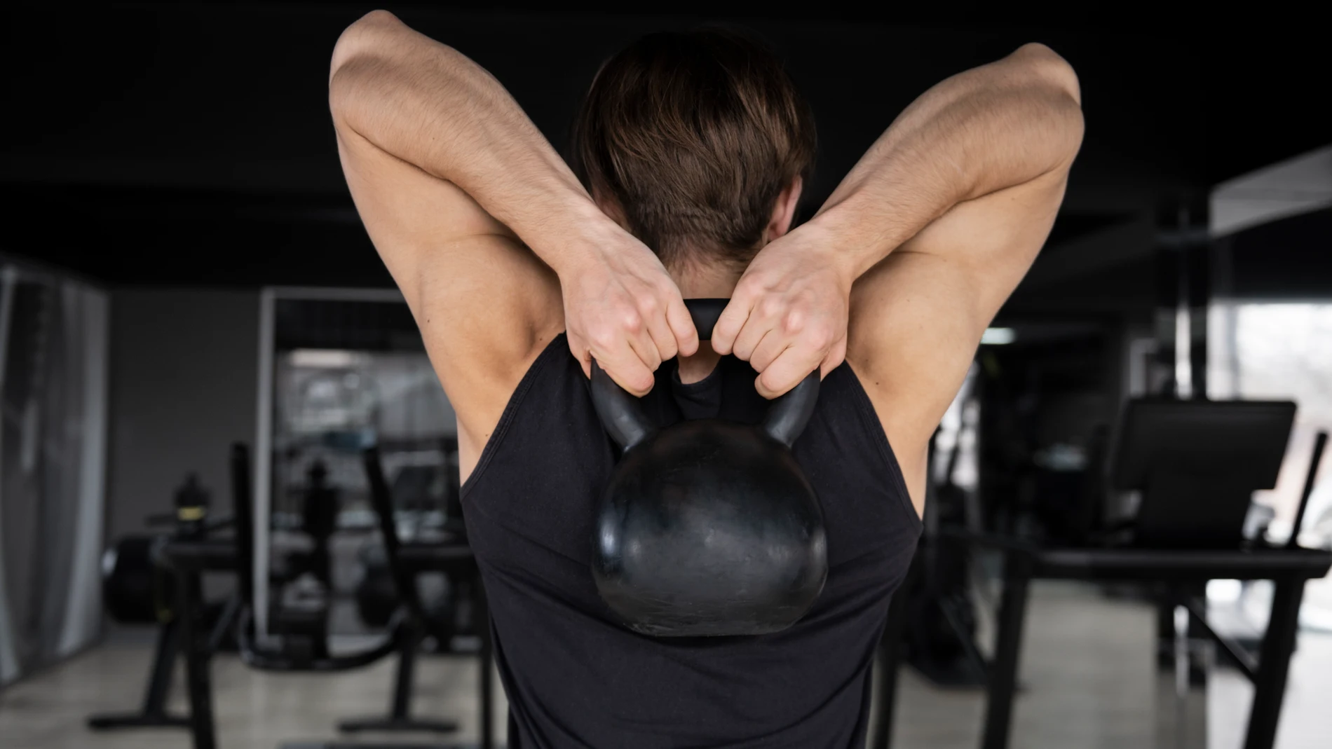 Un hombre realiza un entrenamiento con pesas en el gimnasio