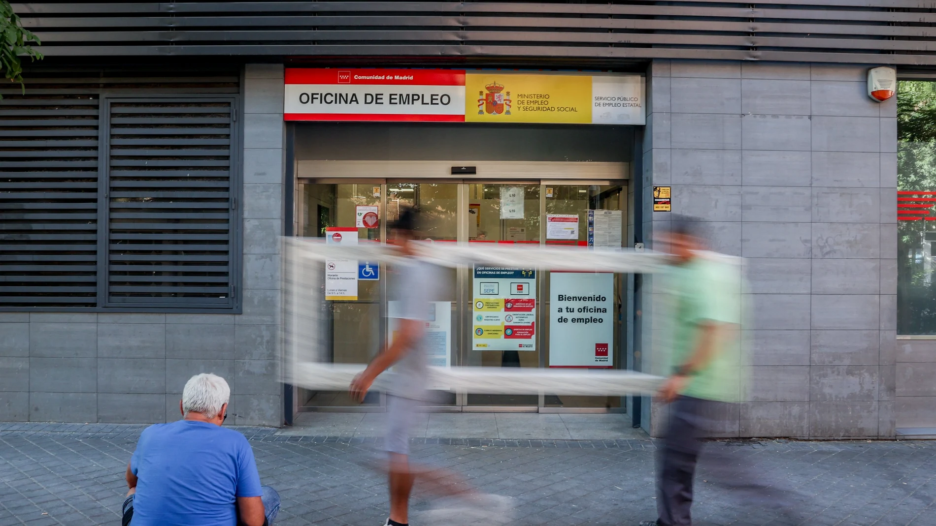 Varias personas pasan por delante de la oficina del SEPE del Paseo de las Acacias, en Madrid (España).