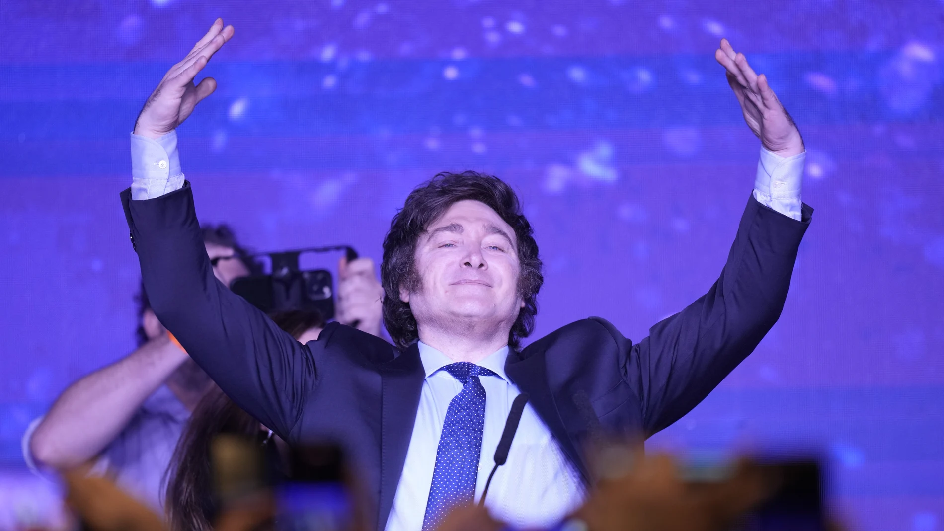 Javier Milei, presidential candidate of the Liberty Advances coalition, raises his arms at his campaign headquarters after polling stations closed during primary elections in Buenos Aires, Argentina, Sunday, Aug. 13, 2023.