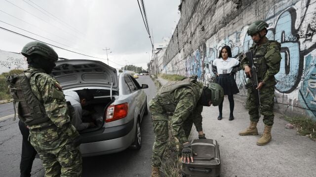 Soldiers inspect a car at a security check point placed in Quito, Ecuador, Tuesday, Aug. 15, 2023. The unprecedented violence shaking Ecuador claimed the life of another political leader Monday, bringing the number of politics-related slayings within the last four weeks to three, including that of a presidential candidate. (AP Photo/Dolores Ochoa)