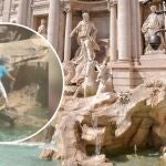 Una turista trepa por la Fontana di Trevi para rellenar su botella de agua 