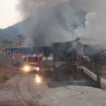 Bomberos trabajan en las labores de extinción de un incendio en una nave de gestión de residuos en Escombreras