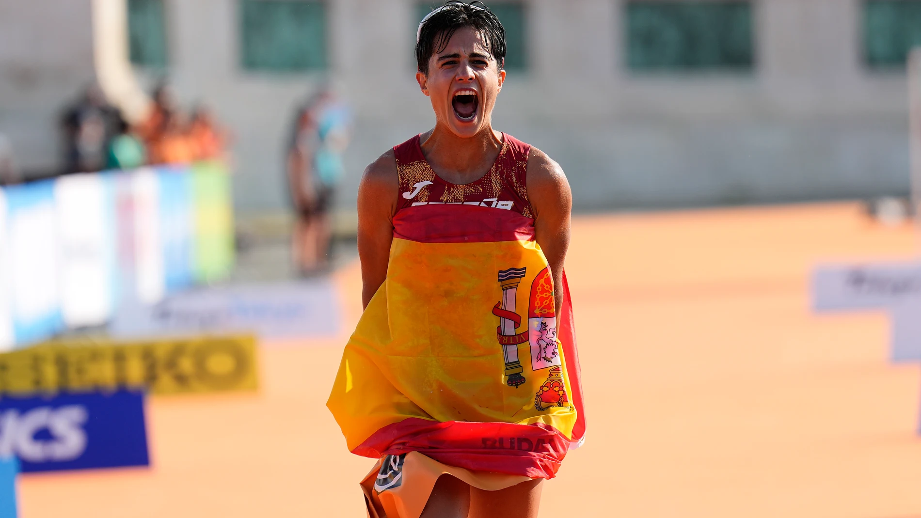 María Pérez, con la bandera española tras cruzar los 20 kilómetros marcha de los Mundiales de Budapest