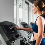Un mujer entrena en una cinta de correr en un gimnasio