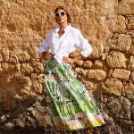 Las influencers 50+ nos demuestran que las faldas midi de estampado tropical están en tendencia y las combinan con sandalias capri
