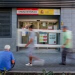 Varias personas pasan por delante de una oficina del SEPE, en Madrid (España). 