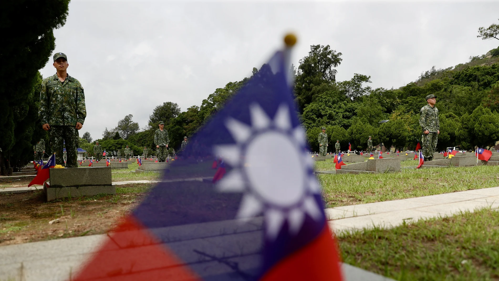 Taiwanese soldiers stand next to the tombstones of the fallen soldiers during the 65th Anniversary of the artillery battle between Taiwan and China, in Kinmen, Taiwan.