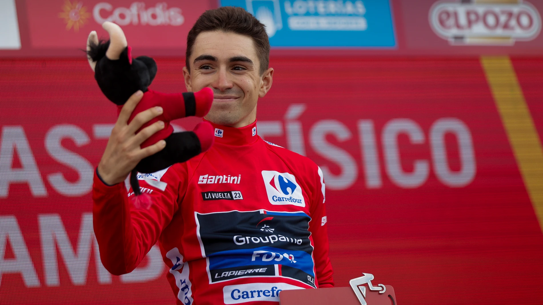 ARCOS DE LAS SALINAS (TERUEL), 31/08/2023.- El ciclista francés y nuevo líder de la general, Lenny Martinez, del equipo Groupama-FDJ, saluda desde el podio con el maillot rojo al término de la sexta etapa de la Vuelta a España disputada entre la localidad castellonense de La Vall d'Uixo y el Pico del Buitre en el Observatorio Astrofísico de Jalambre, de 183,1 kilómetros de recorrido. EFE/ Manuel Bruque