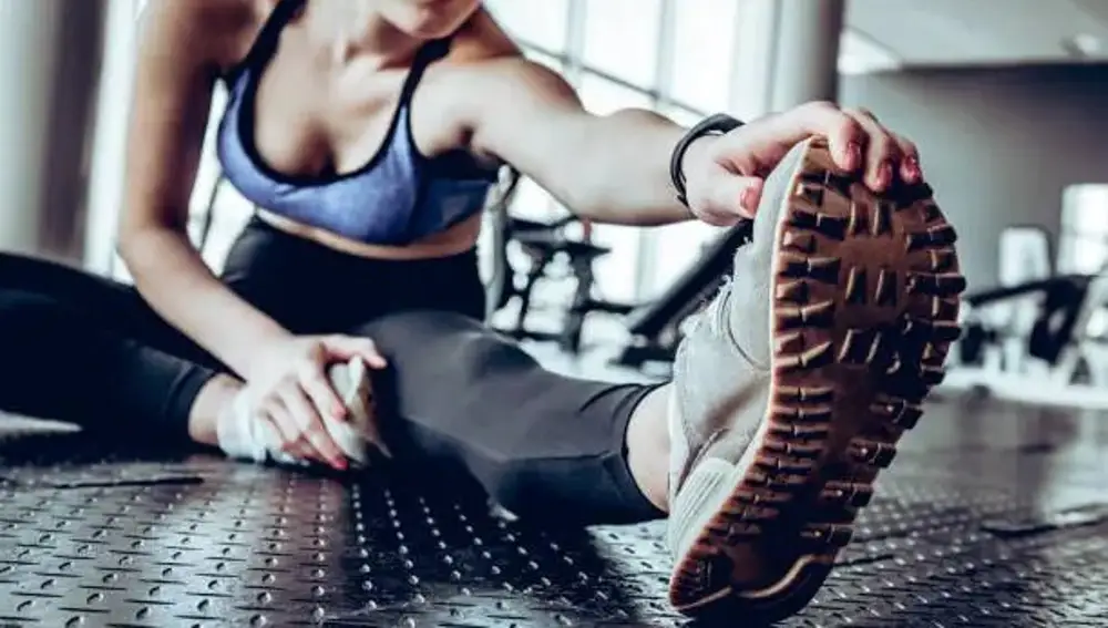 Una joven realiza estiramientos antes de hacer deporte