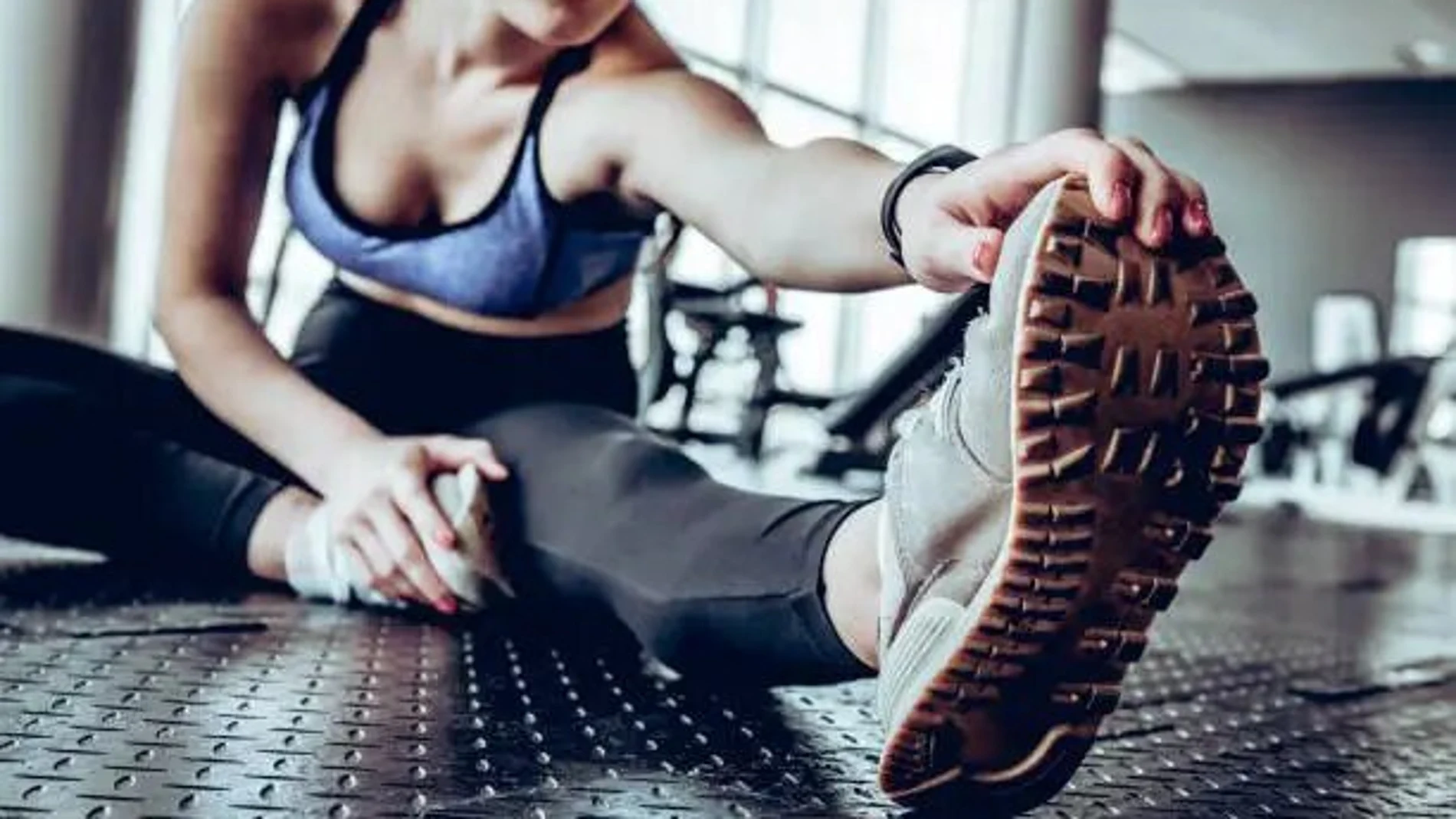 Una joven realiza estiramientos antes de hacer deporte