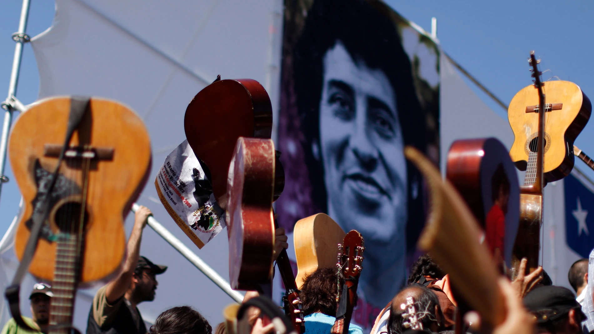 Fellow musicians raise their guitars as a tribute to Chile's folk singer Victor Jara during his burial at the General Cemetery in Santiago, Saturday, Dec. 5, 2009.