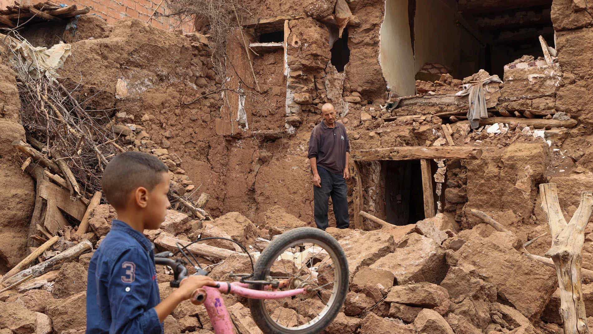 -FOTODELDÍA- ASNI (MARRUECOS), 12/09/2023.- Un hombre permanece de pie en un edificio derruido por el terremoto de Marruecos, este martes en Asni, donde se ha instalado un albergue para afectados. EFE/Kiko Huesca