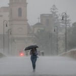 Una persona camina con un paraguas bajo la lluvia en Valencia. Imagen de archivo