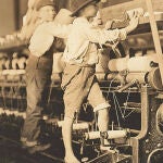 Unos niños trabajando en una fábrica de telares mecánicos donde se les empleaba por su bajo coste