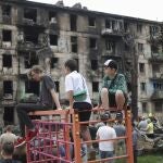 Children look at the scene of the latest Russian rocket attack that damaged a multi-storey apartment building in Kryvyi Rih, Ukraine