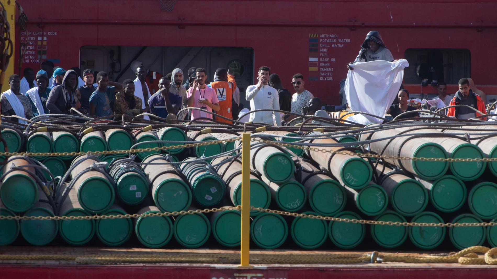 GRAFCAN7642. PUERTO DEL ROSARIO (FUERTEVENTURA) (ESPAÑA), 03/10/2023.- La Guardia Civil ha detenido con cargos de piratería a nueve de los inmigrantes a los que se acusa de haberse amotinado y amenazado con cuchillos a los marineros del remolcador de Países Bajos que los había rescatado de dos pateras en el Atlántico, a unos 105 kilómetros al este de Lanzarote. En la imagen, uno de 79 inmigrantes rescatados muestra una tela blanca al dispositivo policial que los esperaba en el muelle de Puert...