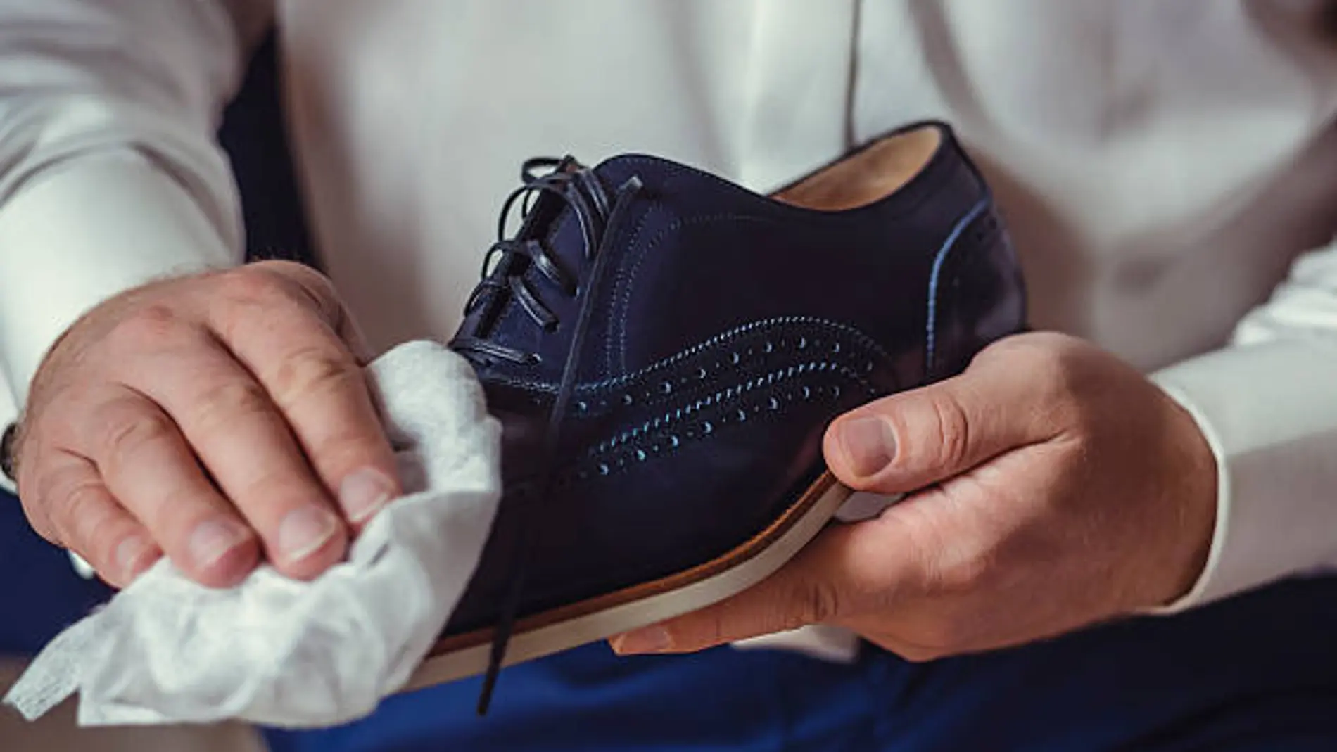 Un hombre limpia sus zapatos
