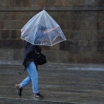 Una persona caminado bajo lluvia y fuerte viento en Toledo
