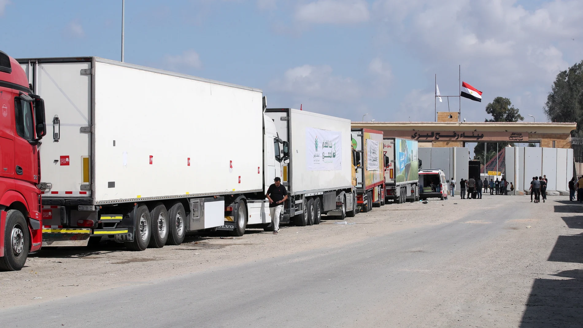 Camiones de un convoy de ayuda humanitaria estacionados frente a la puerta fronteriza entre Egipto y Gaza, en Rafah