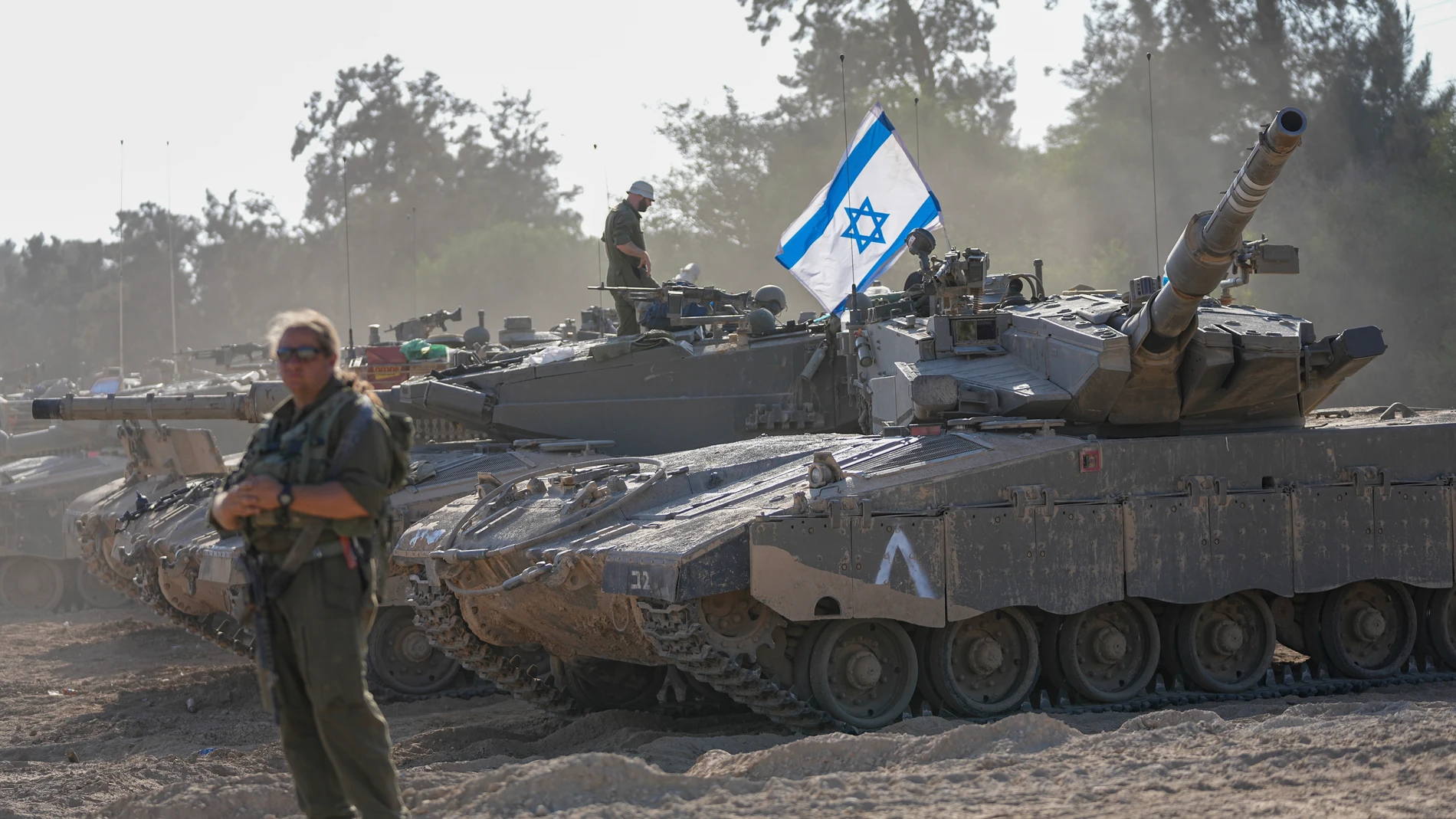 Israeli soldiers work on a tank at a staging area near the border with the Gaza Strip, in southern Israel Friday, Oct. 20, 2023. (AP Photo/Ohad Zwigenberg)
