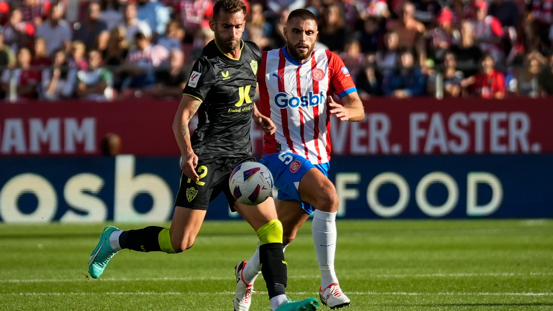 GIRONA, 22/10/2023. El delantero brasileño del Almería Leo Baptistão (i) intenta controlar el balón ante David López, del Girona durante el partido de Liga en Primera División entre el Girona FC - UD Almería, este domingo en el estadio municipal de Montilivi. EFE/David Borrat