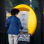 Una mujer saca dinero de un cajero 