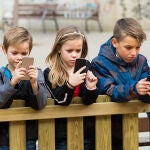 Niñas y niños mirando sus móviles