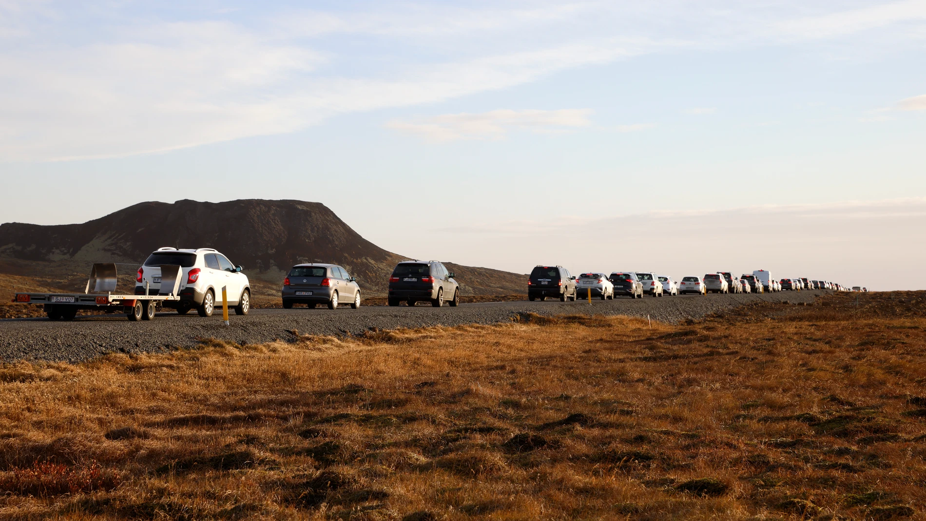 A line of cars queued on a road heading to the town of Grindavik, Iceland Monday Nov. 13, 2023. Residents of Grindavik, a town in southwestern Iceland, have been briefly allowed to return to their homes on Monday after being told to evacuate on Saturday after increasing concern about a potential volcanic eruption caused civil defense authorities to declare a state of emergency in the region. (AP Photo/Brynjar Gunnarsson)