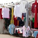 Personas pasean por los puestos de un mercadillo 