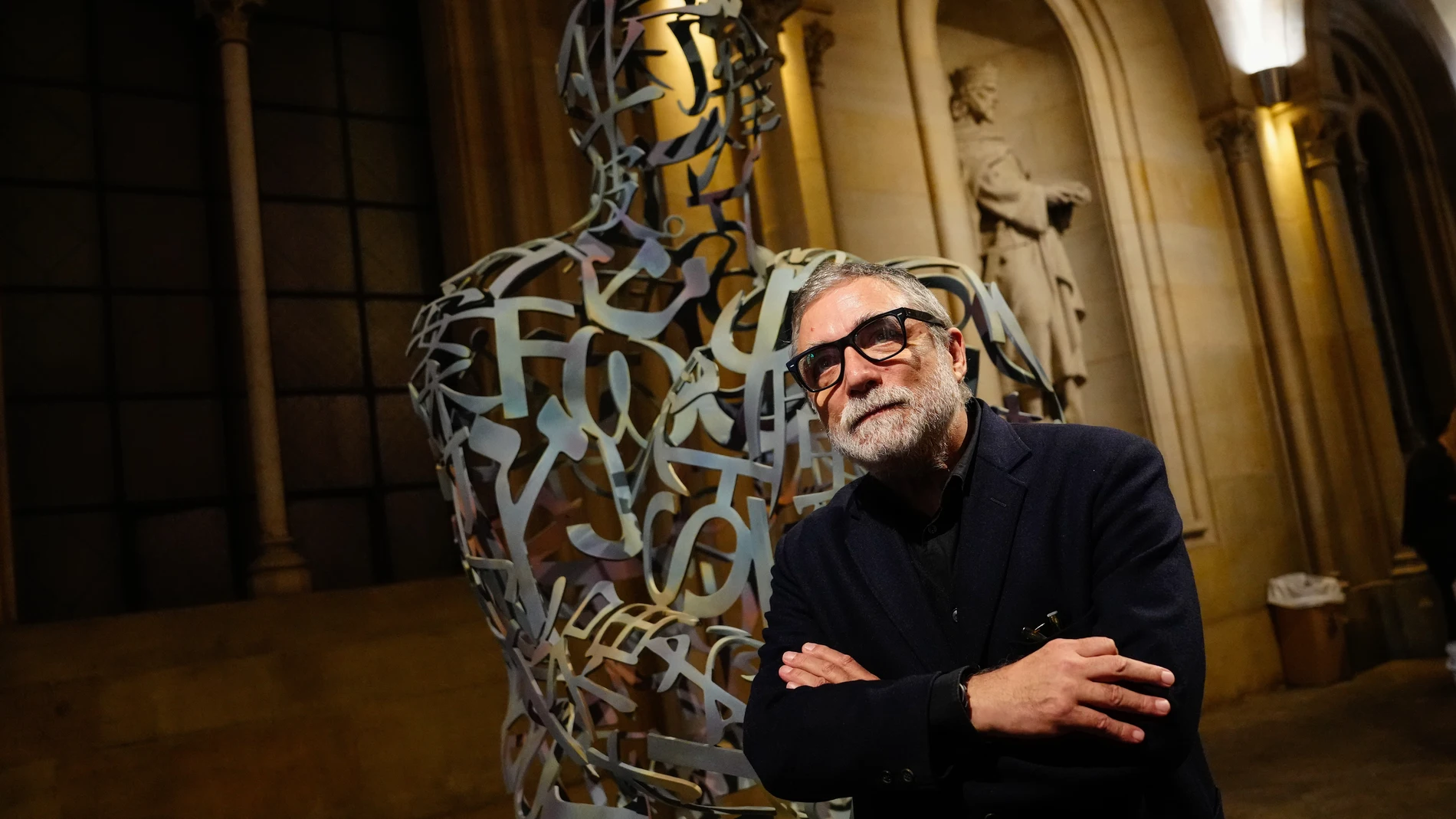 GRAFCAT6347 BARCELONA 15/11/2023.- El escultor Jaume Plensa, posa junto a la escultura Arrels 2018, cedida por el artista a la Universidad de Barcelona e instalada el vestíbulo principal del edificio histórico para dar la bienvenida a los visitantes simbolizando una celebración de la vida y el conocimiento. EFE/Enric Fontcuberta