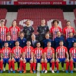 Dos aficionados posan con los jugadores del Atlético de Madrid 23-24 en la foto oficial