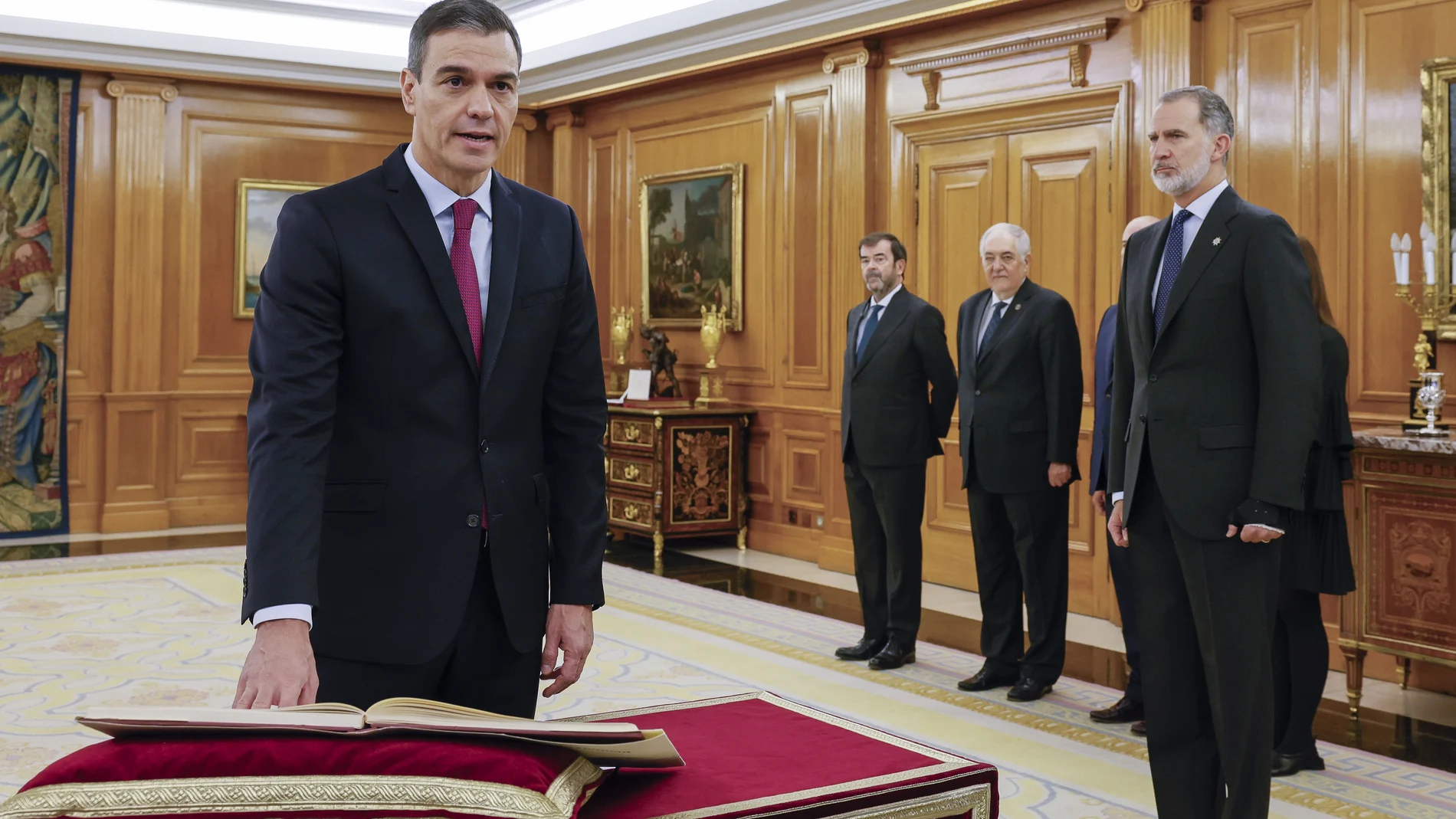 Pedro Sánchez (i) promete su cargo de presidente del Gobierno ante el rey Felipe VI (d) y un ejemplar de la Constitución, este viernes en el Salón de Audiencias del Palacio de la Zarzuela en Madrid.