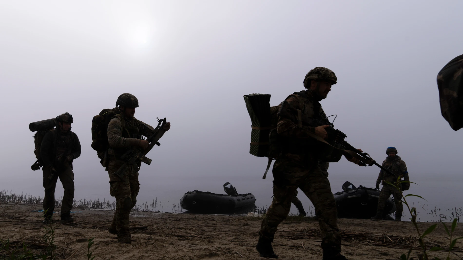 Ukrainian servicemen walk on the shore of Dnipro river after exiting a boat at the frontline near Kherson, Ukraine, Sunday Oct. 15, 2023. (AP Photo/Mstyslav Chernov)