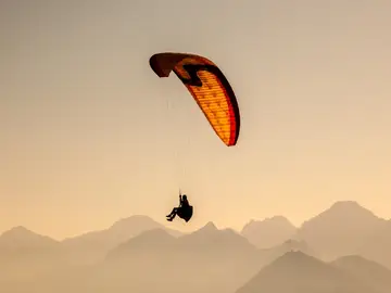 Una persona volando en parapente Una persona volando en parapente