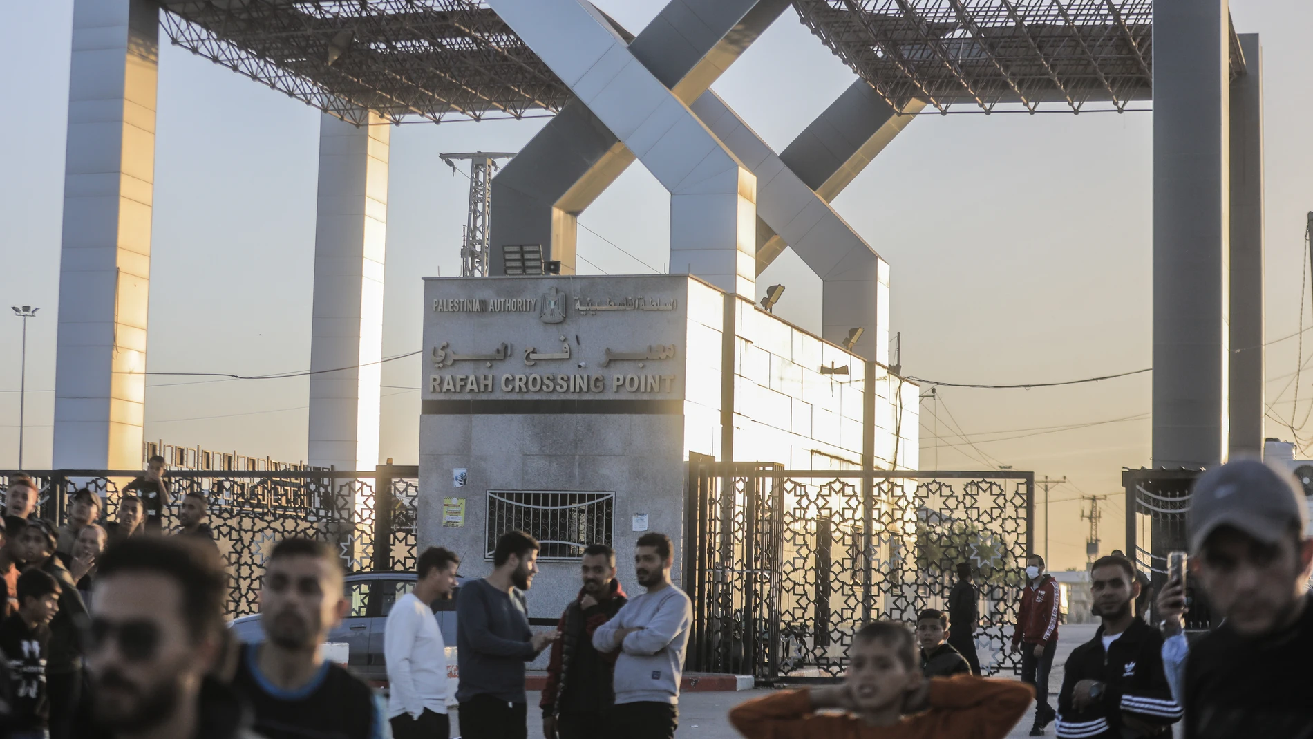 24 November 2023, Palestinian Territories, Rafah: Palestinians gather in front of the Rafah crossing gate to await the passage of vehicles transporting Israeli hostages from the Gaza Strip to Egypt. Photo: Mohammed Talatene/dpa 24/11/2023 ONLY FOR USE IN SPAIN