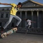 Dos jovenes practican skate delante del congreso 
