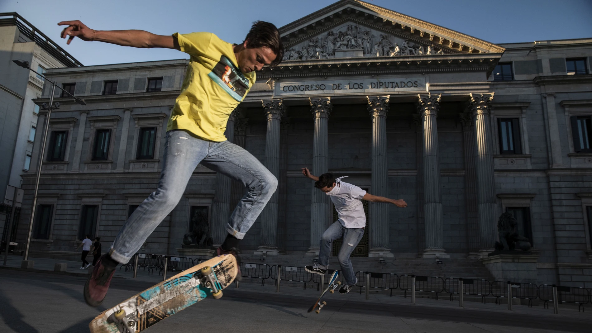 Dos jovenes practican skate delante del congreso