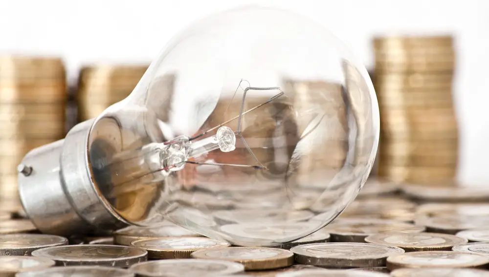 Una bombilla sobre monedas de euro