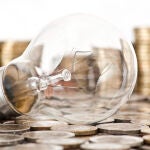 Una bombilla sobre monedas de euro