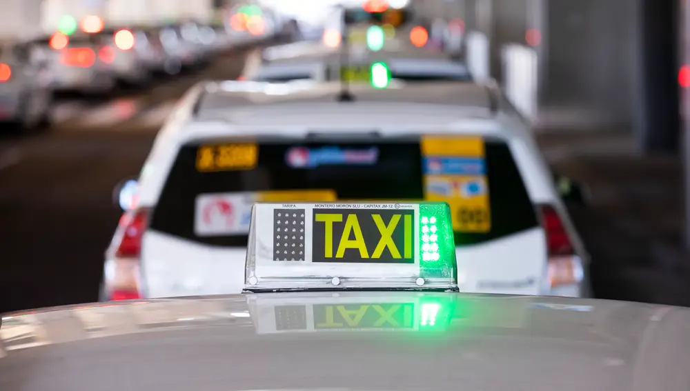 Imagen de una luz de taxi en verde sobre uno de ellos en la T4 de Madrid..
